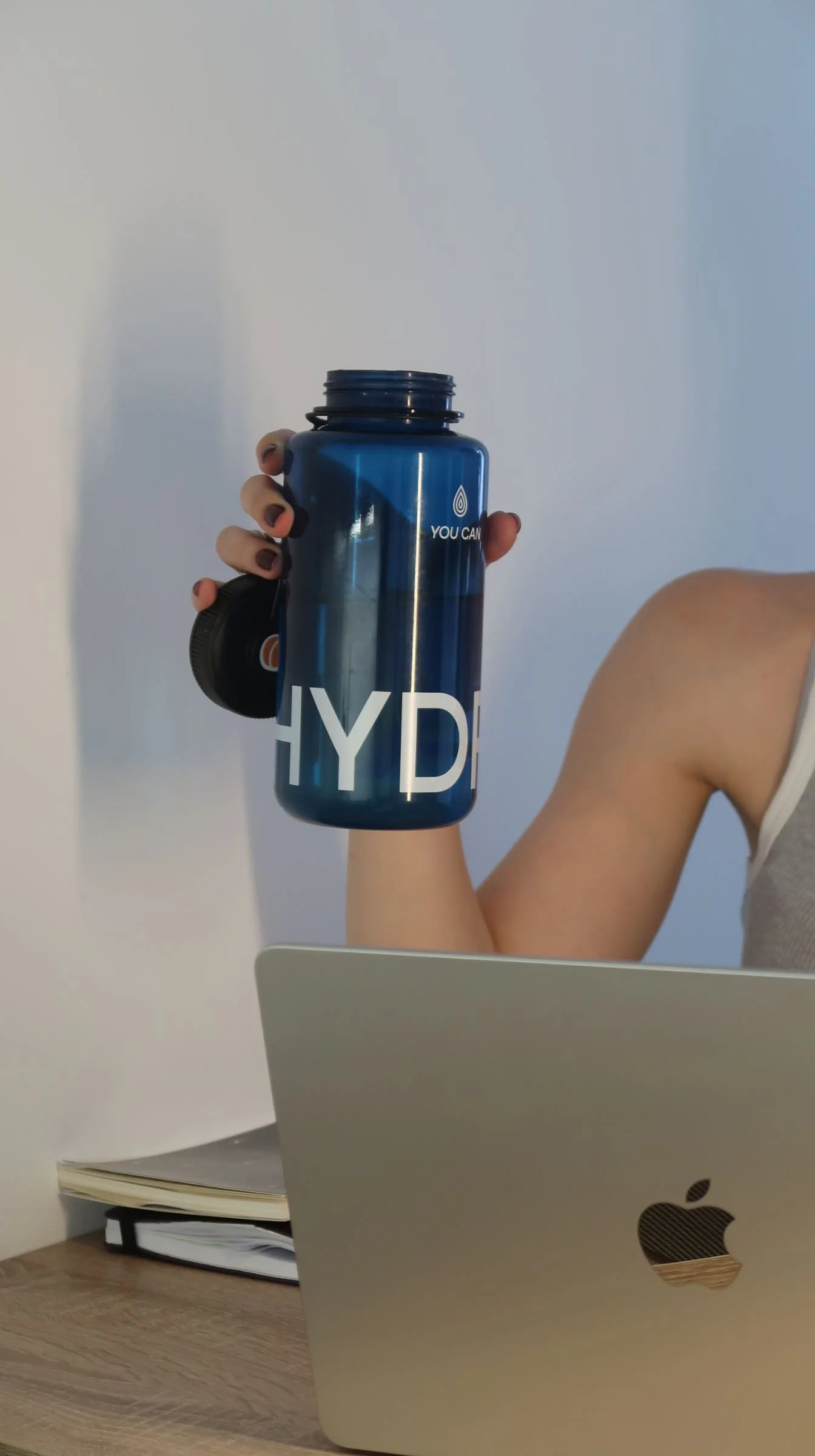 Пляшка для води з електролітами Гідрія/Hydria в руці людини за ноутбуком під час роботи